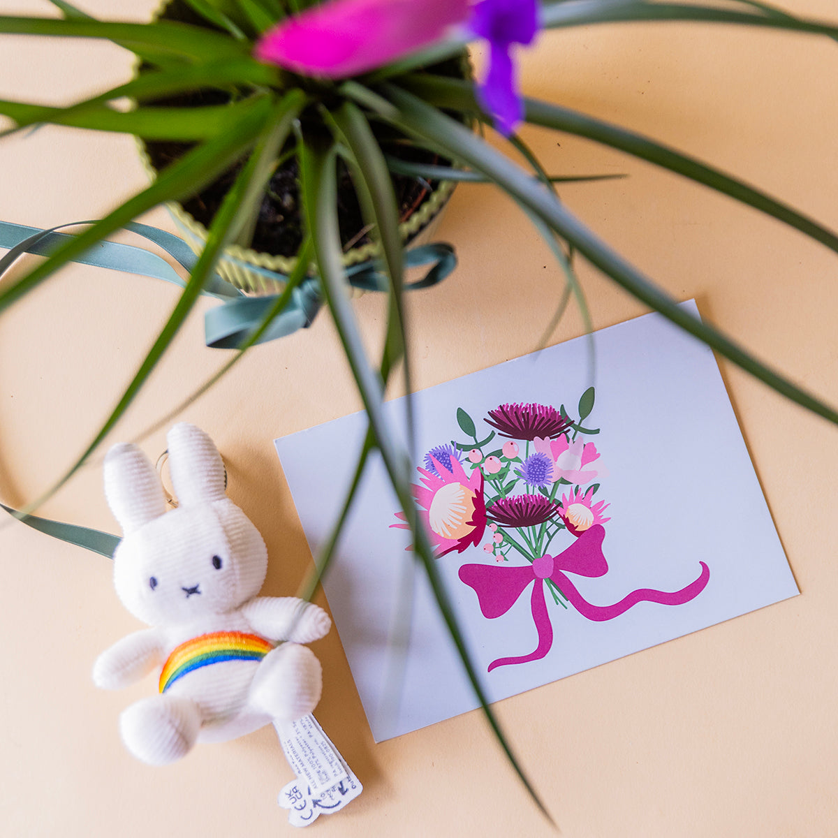 Cenital llavero Miffy arcoiris peluche y tarjeta protea floral con tillandsia rosa al fondo, regalo a domicilio - Colvin